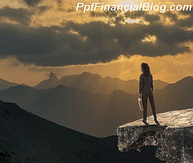 Una mujer con un maletín en la cima de una montaña.